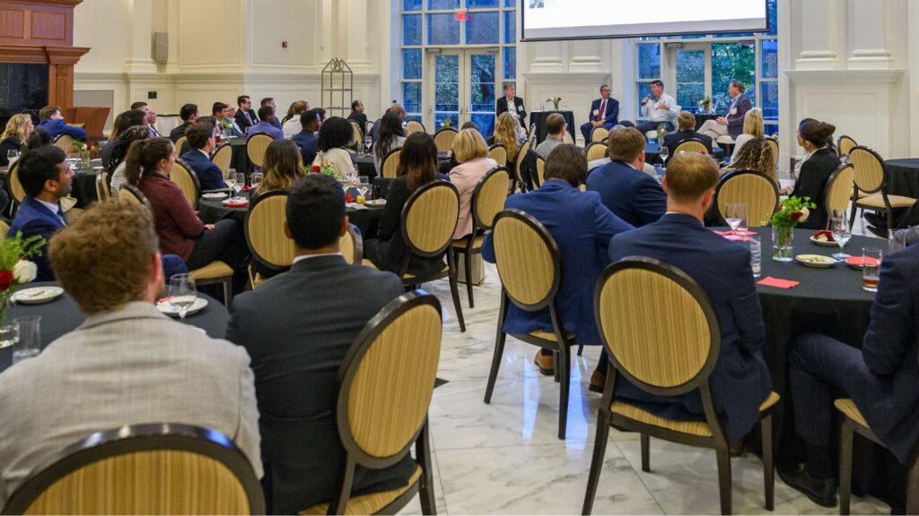 The crowd at the Finance Sector Summit sitting at tables, watching a panel of speakers