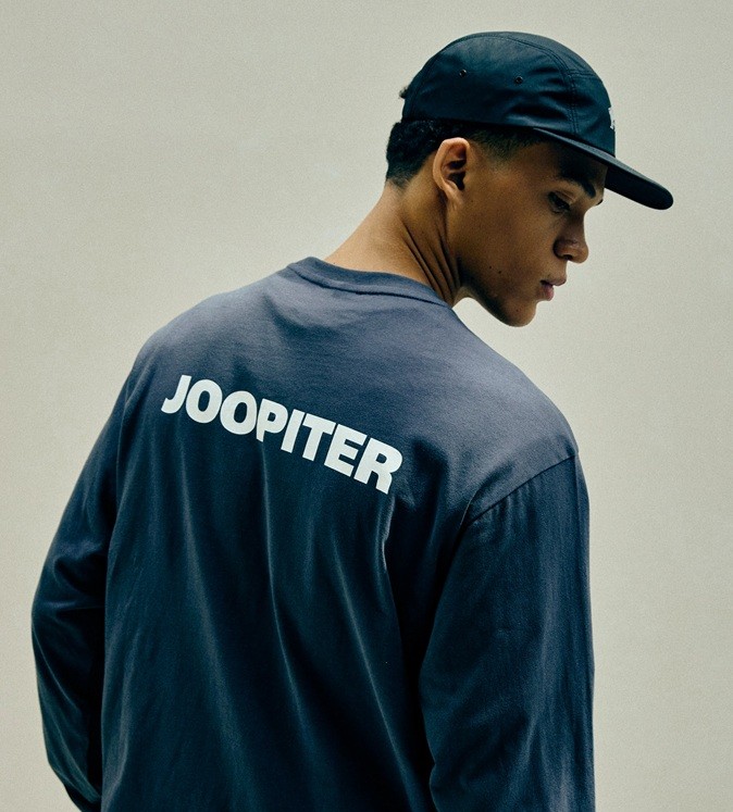 A man in a baseball cap and Joopiter-branded sweatshirt