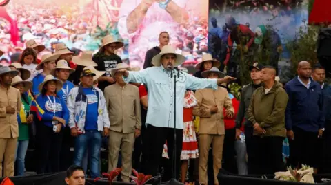 Reuters A moustachioed man in a straw hat addresses an assembly in a hall.
