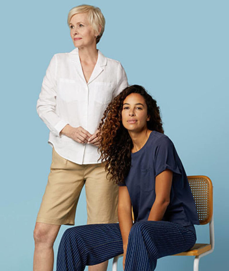 Two female models posing wearing NYDJ clothes.