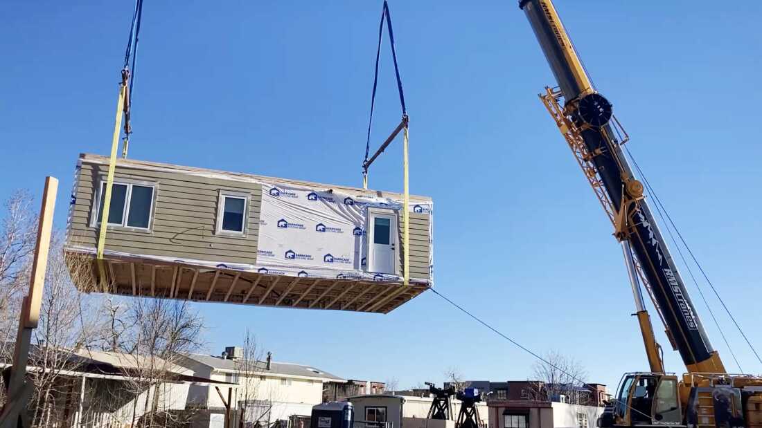 Part of a modular home built by Boulder Valley High School students is lifted into place in an affordable housing development in Boulder, Colo.