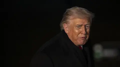 Anadolu via Getty Images United States President Donald Trump pictured in a close up, wearing  a black coat, speaks to the press before he departs the White House en route to Davos, Switzerland, to attend the World Economic Forum (WEF), on 20 January, 2026,