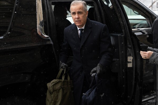 Canadian Prime Minister Mark Carney arrives by motorcade to Parliament Hill in Ottawa, Tuesday, Jan. 27, 2026. (Adrian Wyld/The Canadian Press via AP)