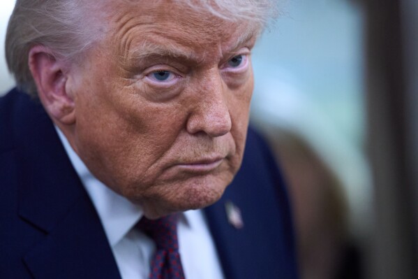 President Donald Trump speaks with reporters aboard Air Force One after leaving the World Economic Forum in Davos for Washington, Thursday, Jan. 22, 2026. (AP Photo/Evan Vucci)