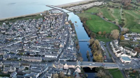 Getty Images An aerial image showing rows of houses in Nairn and, at the bottom of the image, the A9 where it crosses the River Nairn. Nairn Harbour and the Moray Firth are visible at the top of the picture.