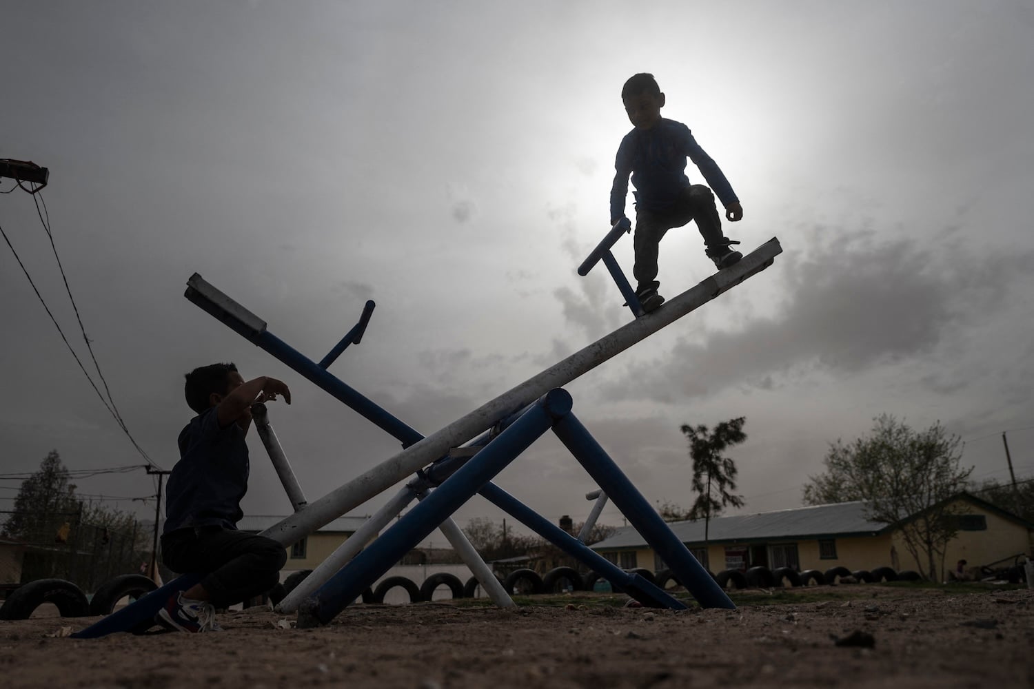 Central American migrant children play on a seesaw at a shelter in Ciudad Juárez, state of Chihuahua, Mexico.