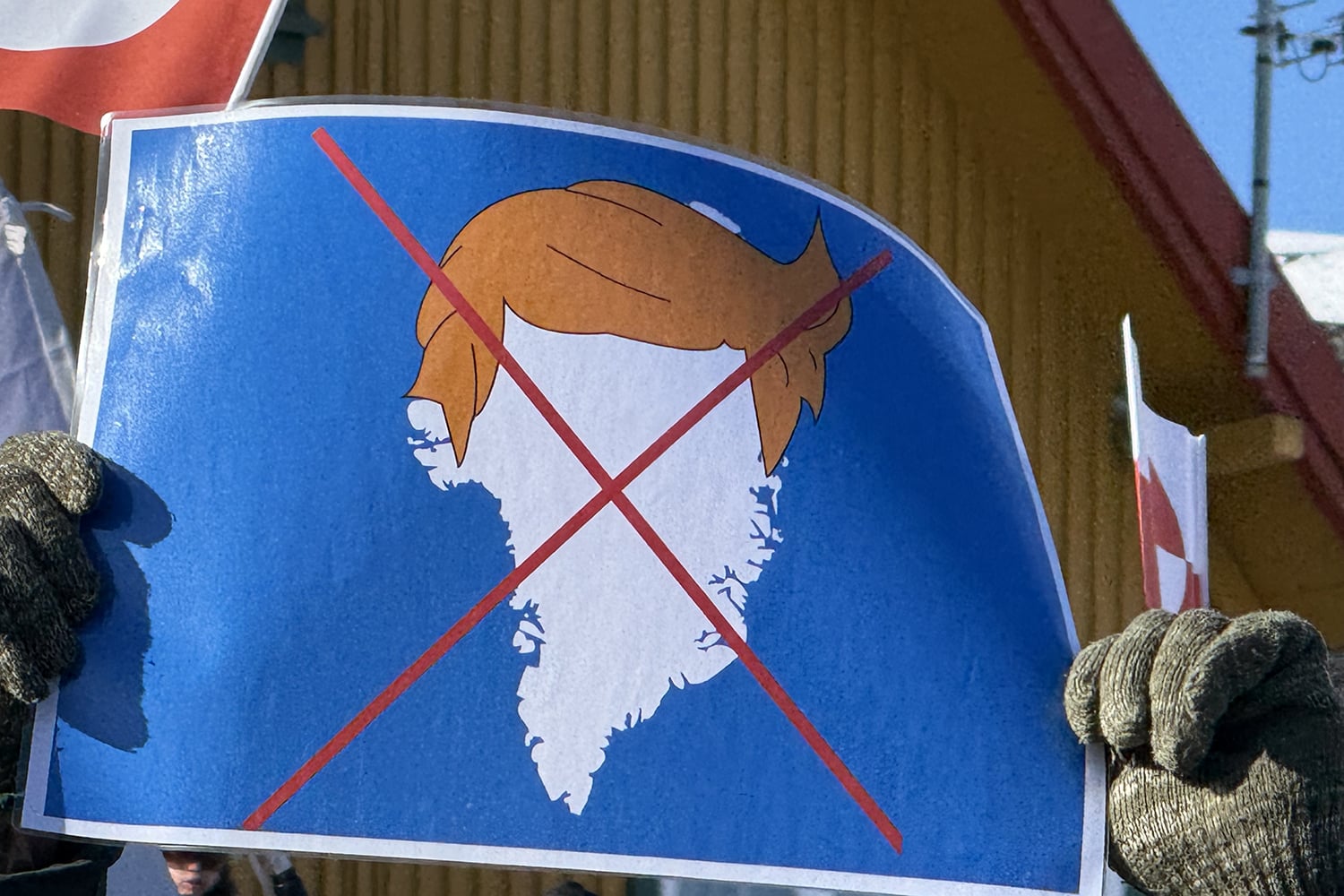 A protester holds up a sign depicting U.S. President Donald Trump’s signature hair atop the outline of Greenland during a demonstration near the U.S. Consulate building outside Nuuk, Greenland.