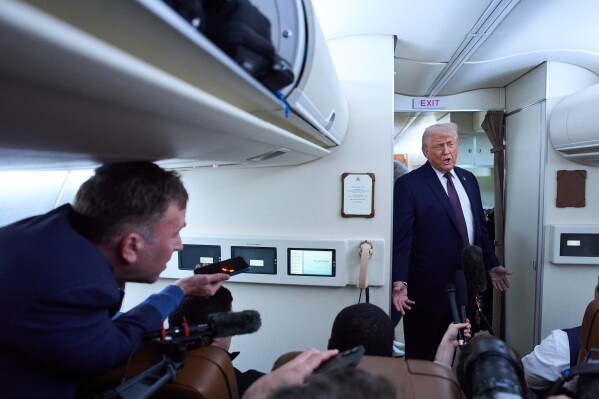 President Donald Trump speaks with reporters aboard Air Force One after leaving the World Economic Forum in Davos for Washington, Thursday, Jan. 22, 2026. (AP Photo/Evan Vucci)