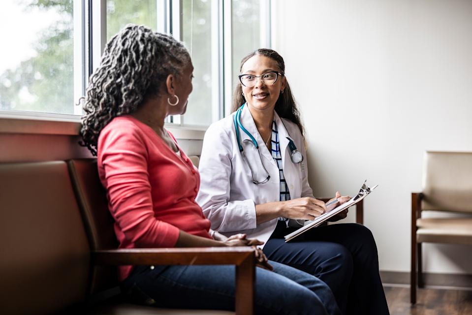 Female doctor talking with senior woman in waiting room
