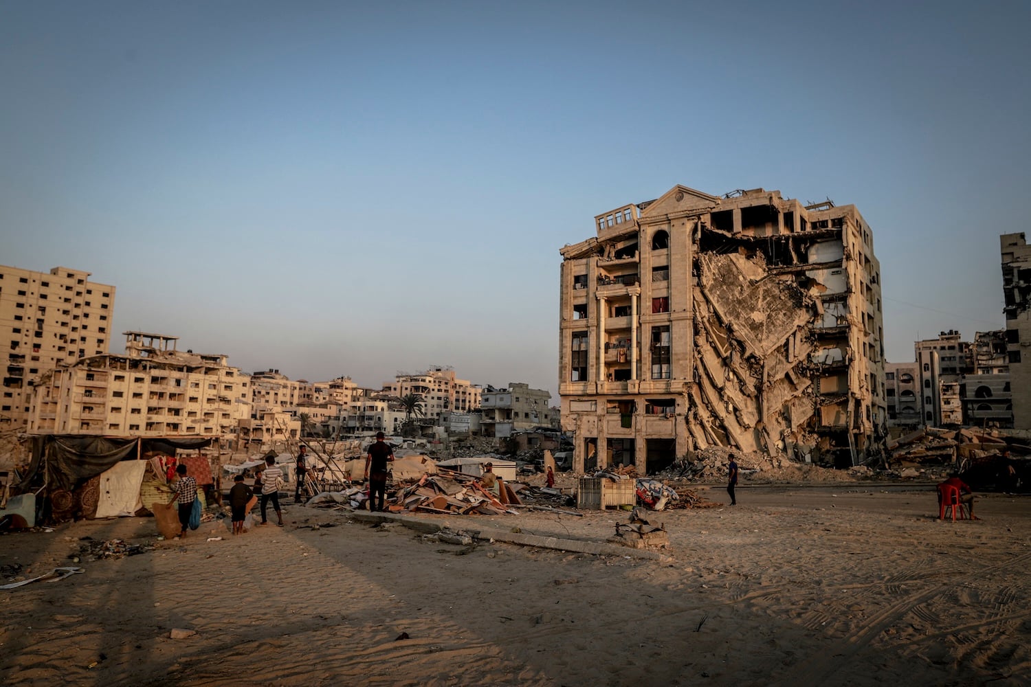 People walk past a heavily damaged building in Gaza City on Nov. 10, 2025.